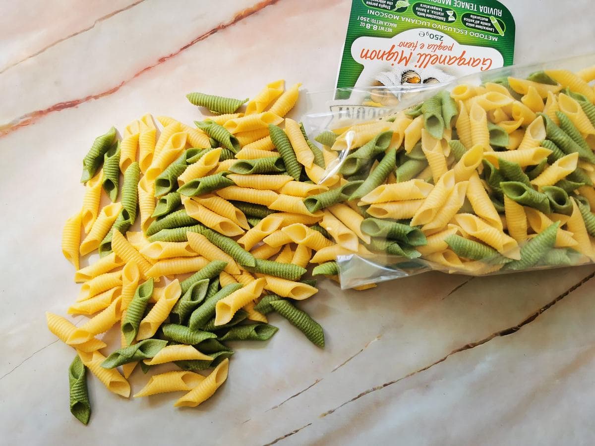 dried green and yellow garganelli pasta on marble worktop