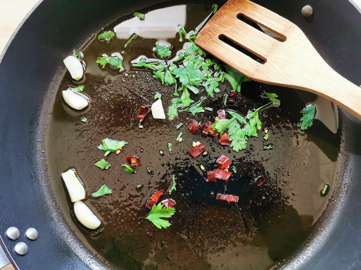 peeled garlic cloves, chopped parsley and chopped chilli pepper in skillet with olive oil.