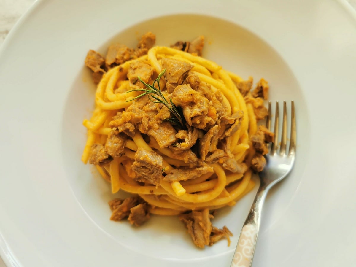 Duck ragu pasta served in a white bowl.