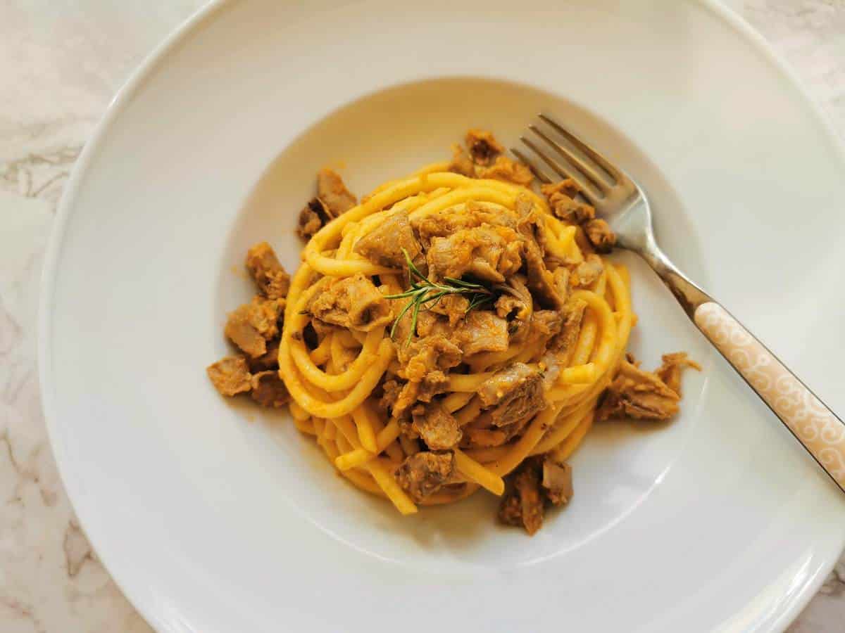 Duck ragu pasta in a white bowl.