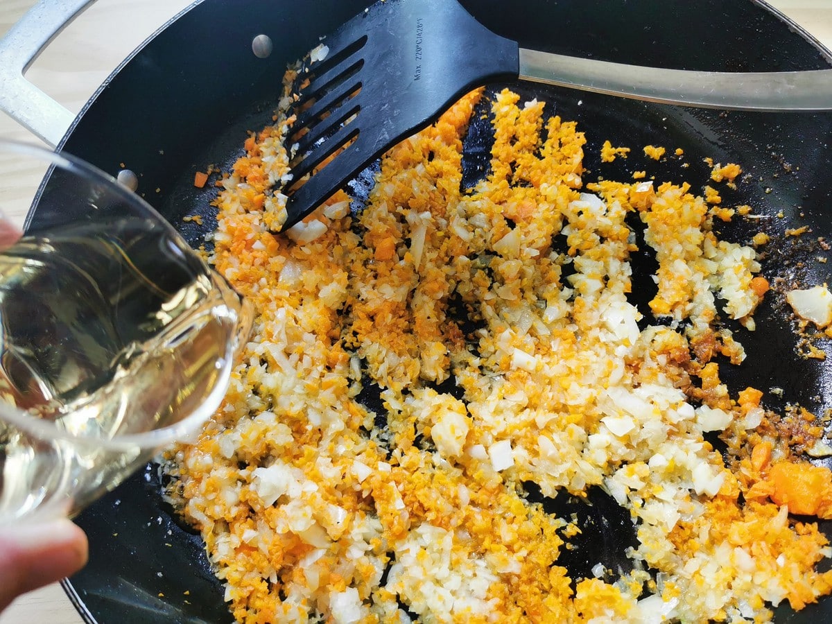 Deglazing the sauté pan with white wine.