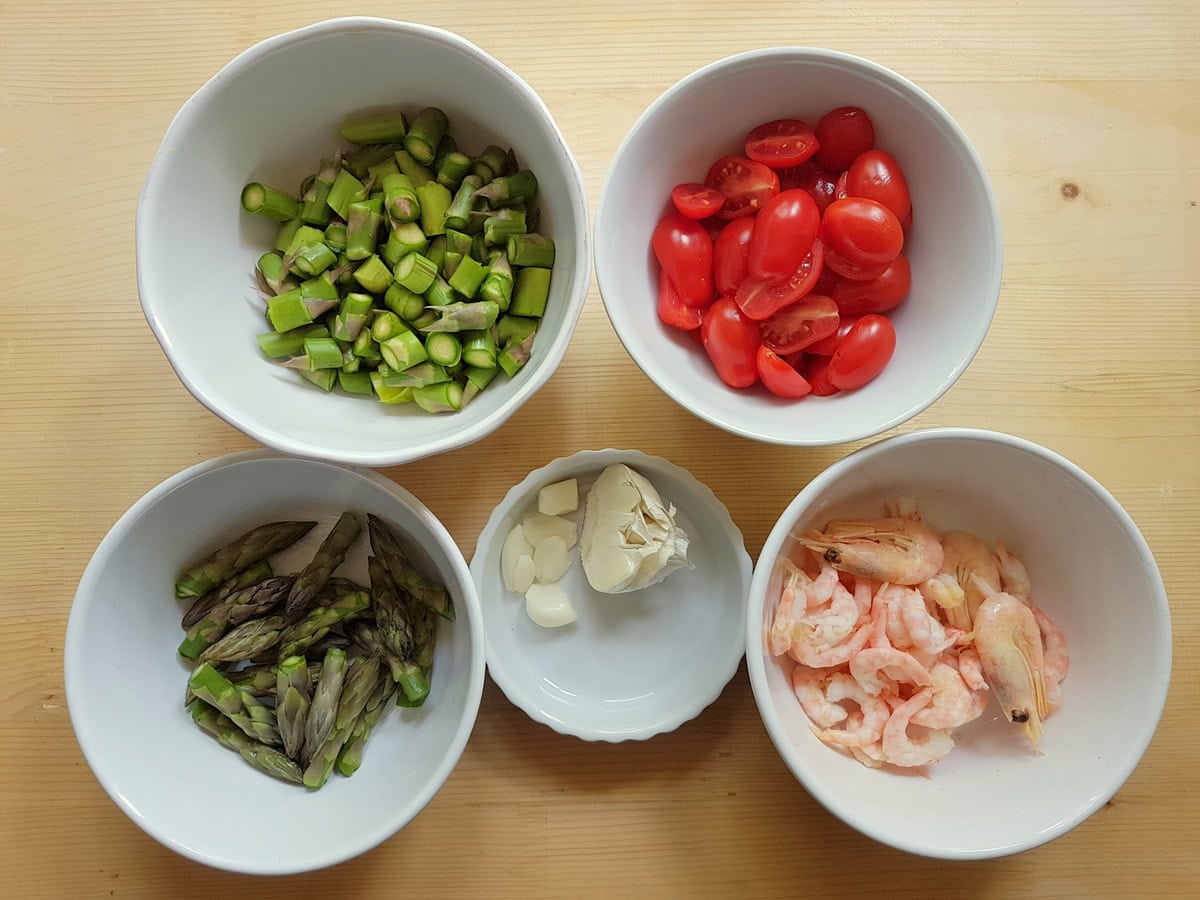 Prepare asparagus, tomatoes, shrimp and garlic all in separate white bowls.