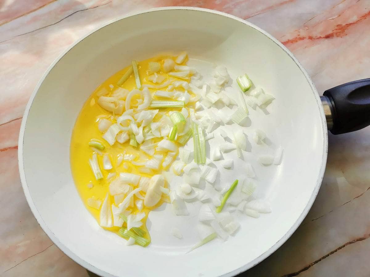 Chopped spring onions and garlic  with olive oil in frying pan