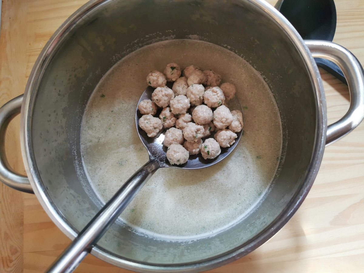 Tiny veal meatballs cooking in beef broth.