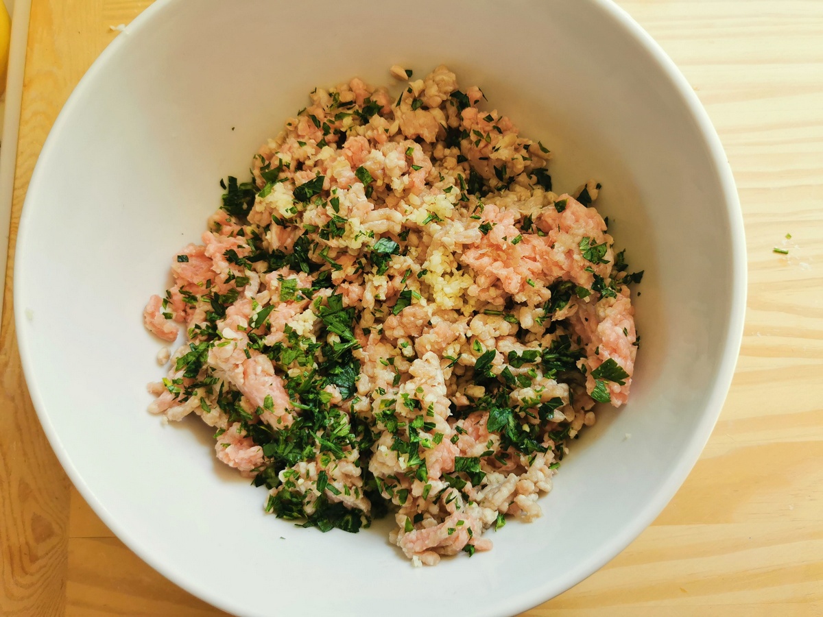 Ground veal with chopped parsley and garlic in large bowl.