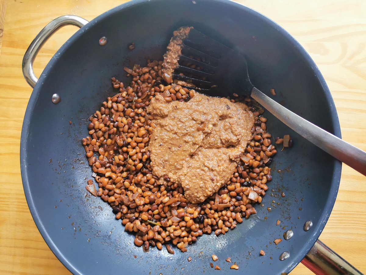 Creamy bean purée with other cooked Trasimeno beans in deep frying pan.