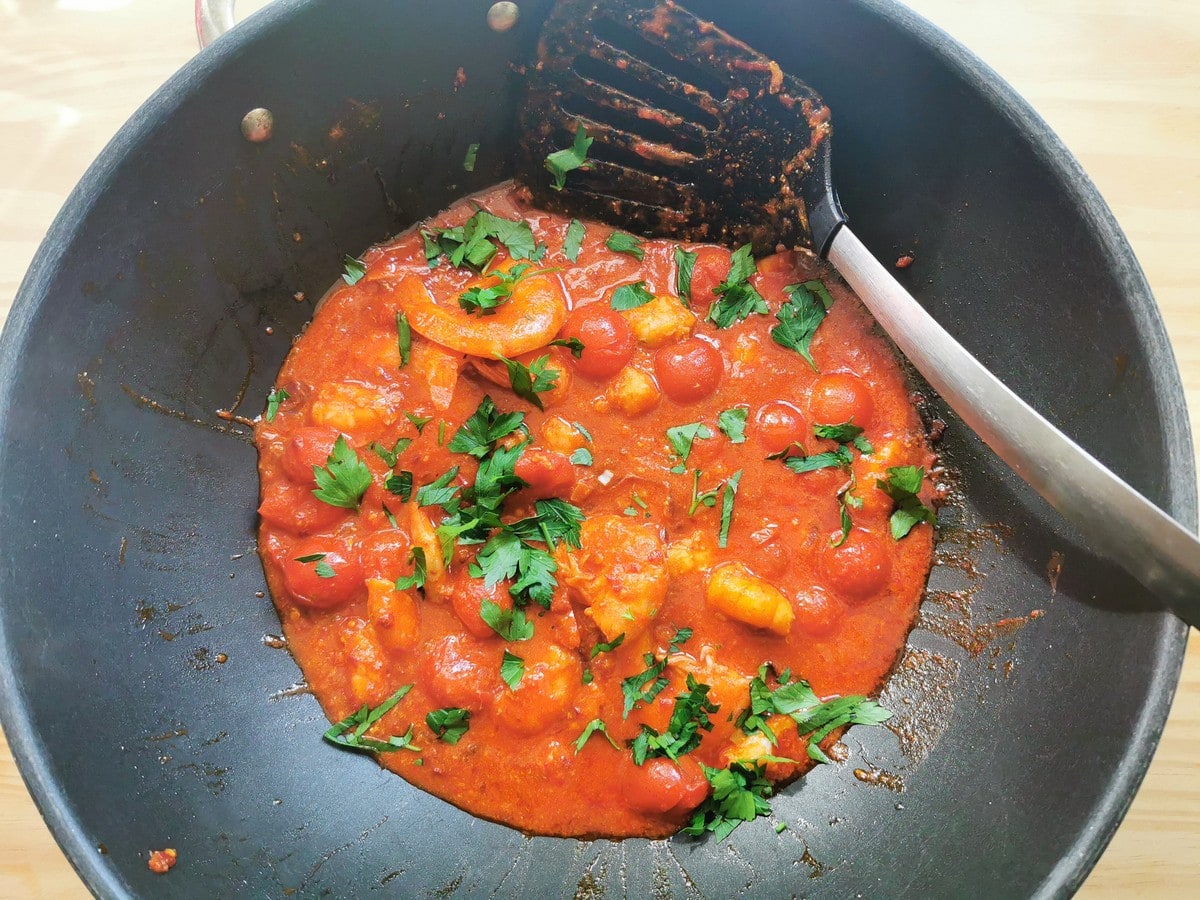Ready cooked nduja sauce with shrimp in skillet.