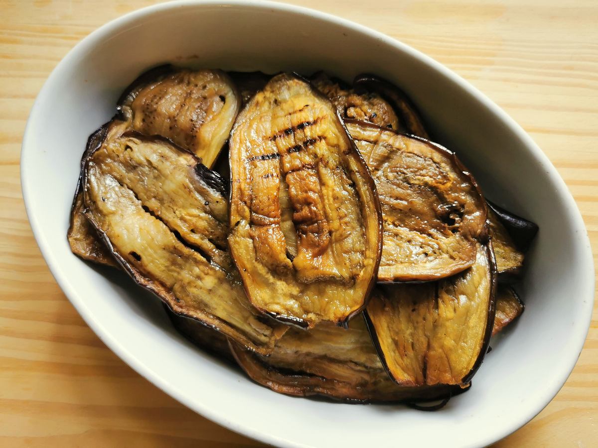 Fried eggplant slices in white dish.