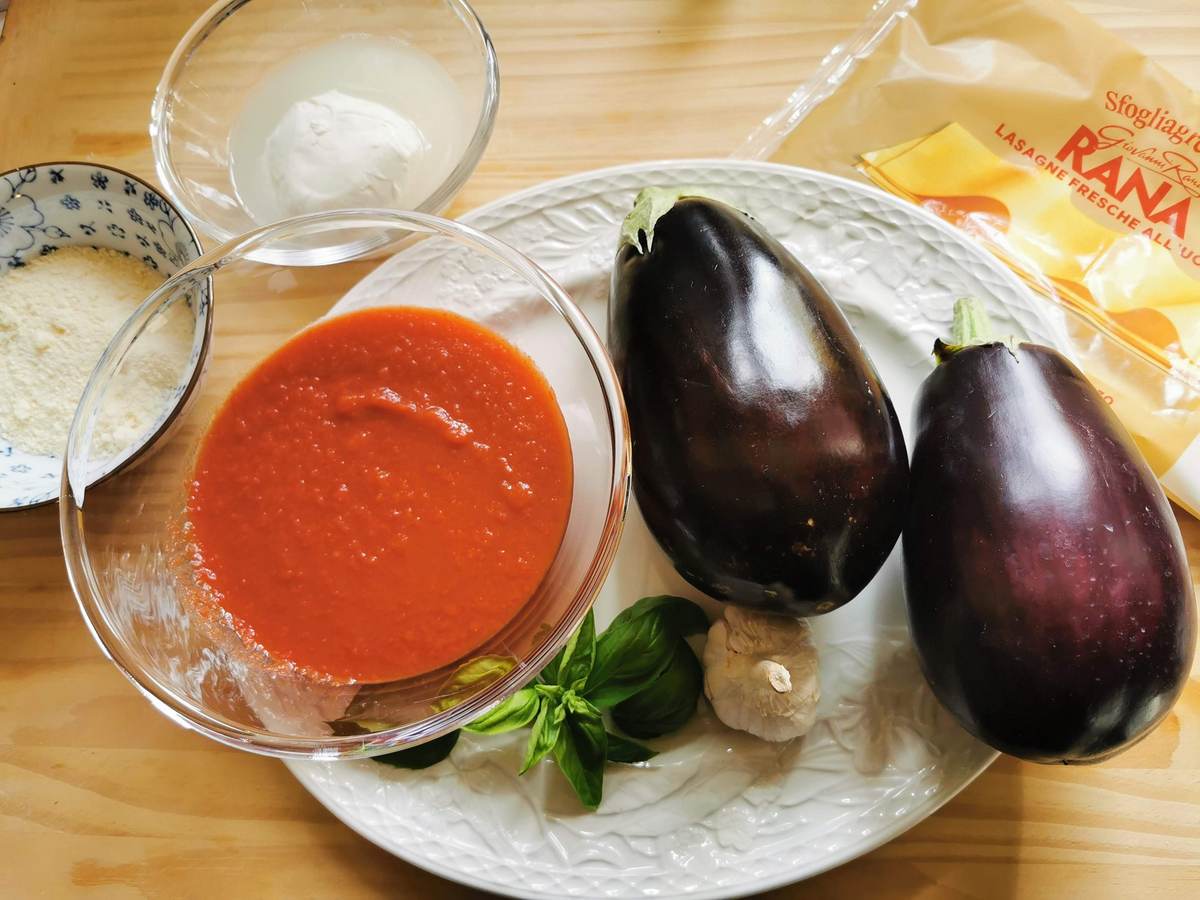 Ingredients for eggplant parmigiana lasagna on white plate.