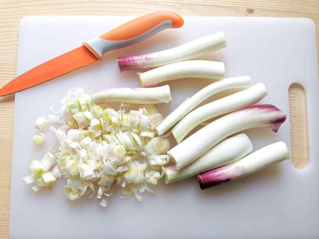 Peeled and chopped Tropea onions on white chopping board.