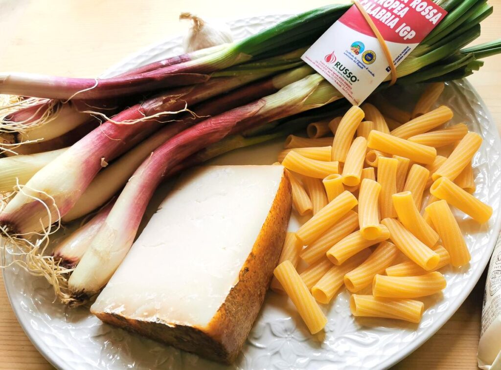 ingredients for elicoidali with tropea onions on white plate