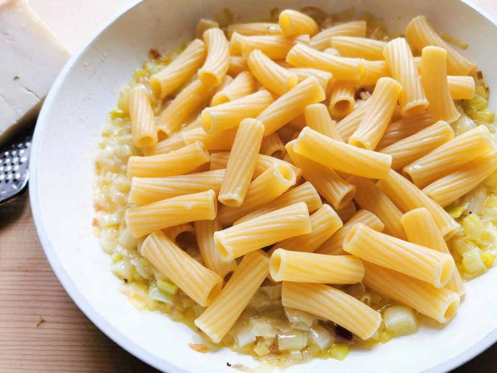 Cooked elicoidali pasta in pan with onion sauce