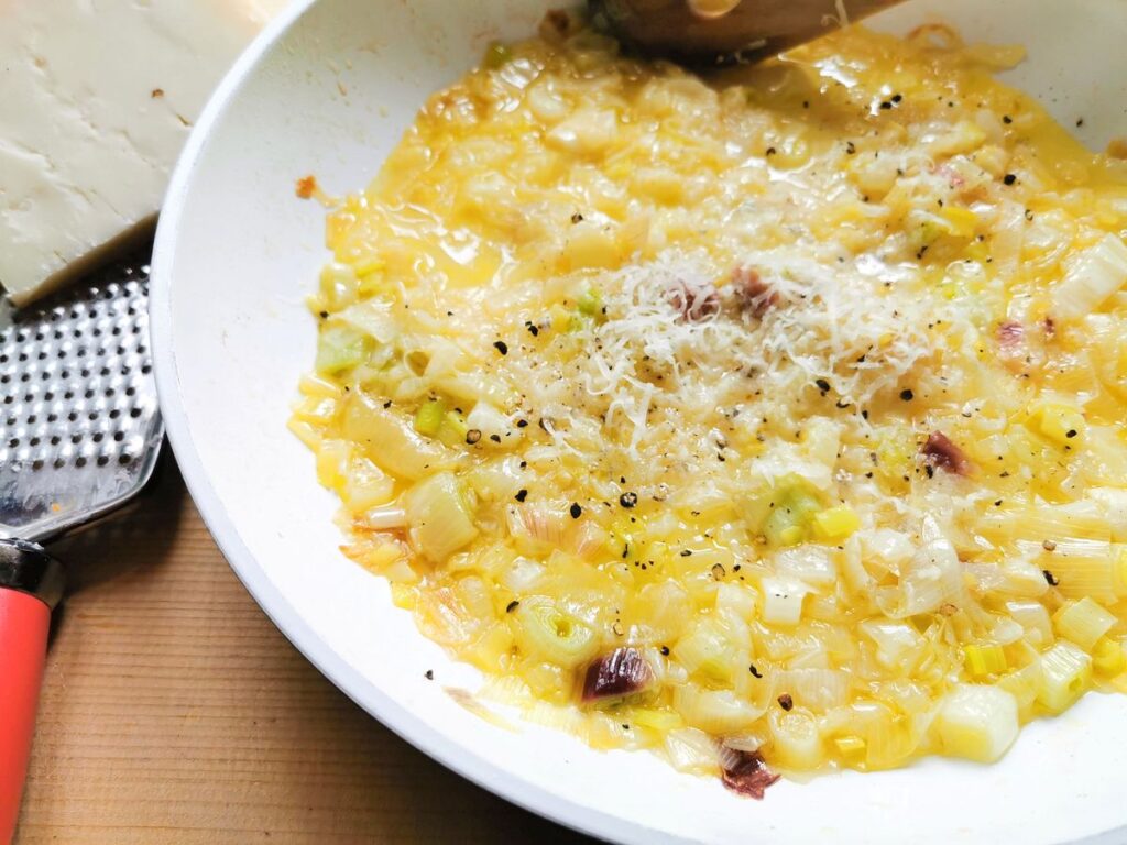 Ready onion sauce in frying pan with grated pecorino on top