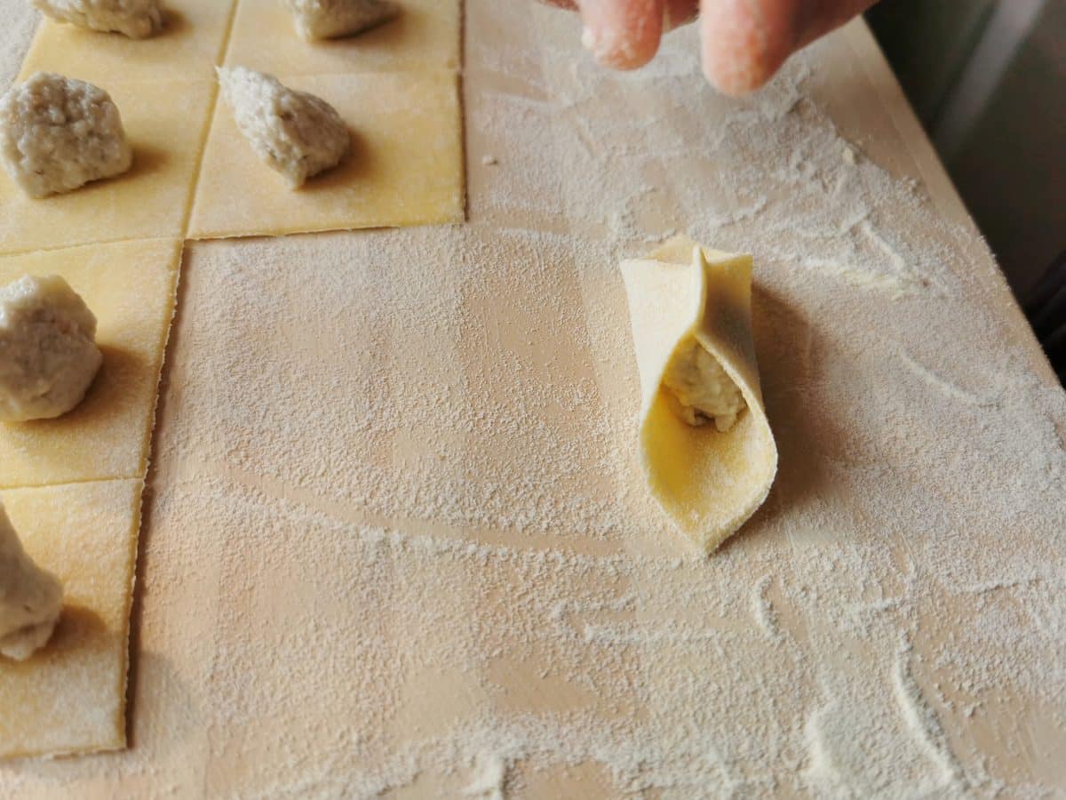 Shaping the fagottini pasta.