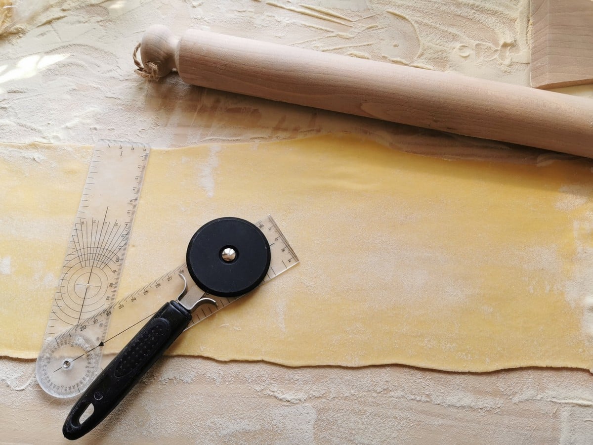 Cutting the pasta dough into squares.