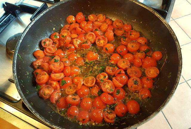 cherry tomatoes cooking in frying pan for fettuccine pasta with giant prawns recipe