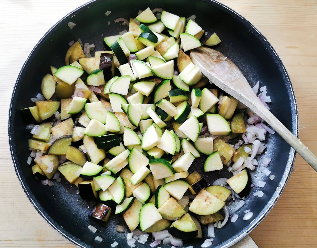 onions, eggplant and zucchini cooking in skillet