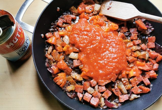 chopped soppressata, guanciale, red onion and peeld fresh tomatoes in skillet with tomato polpa from mutti
