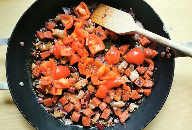 chopped soppressata, guanciale, red onion and peeled tomatoes in skillet
