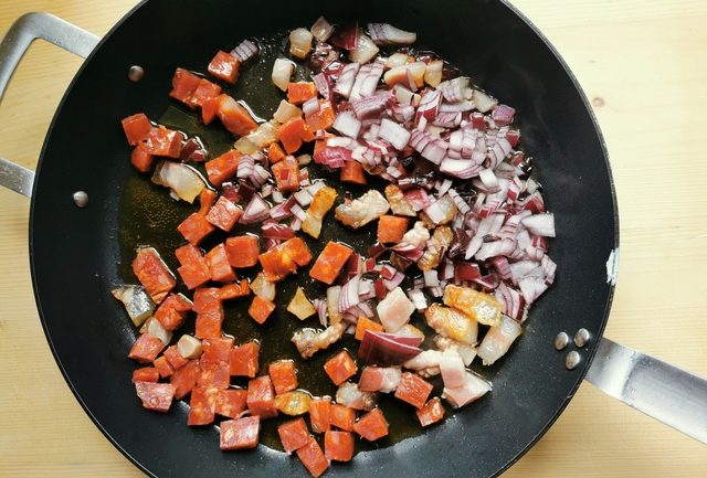 chopped soppressata, guanciale and red onion in skillet with olive oil