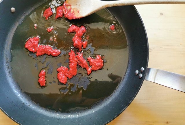 tomato concentrate (pasta) in skillet with olive oil