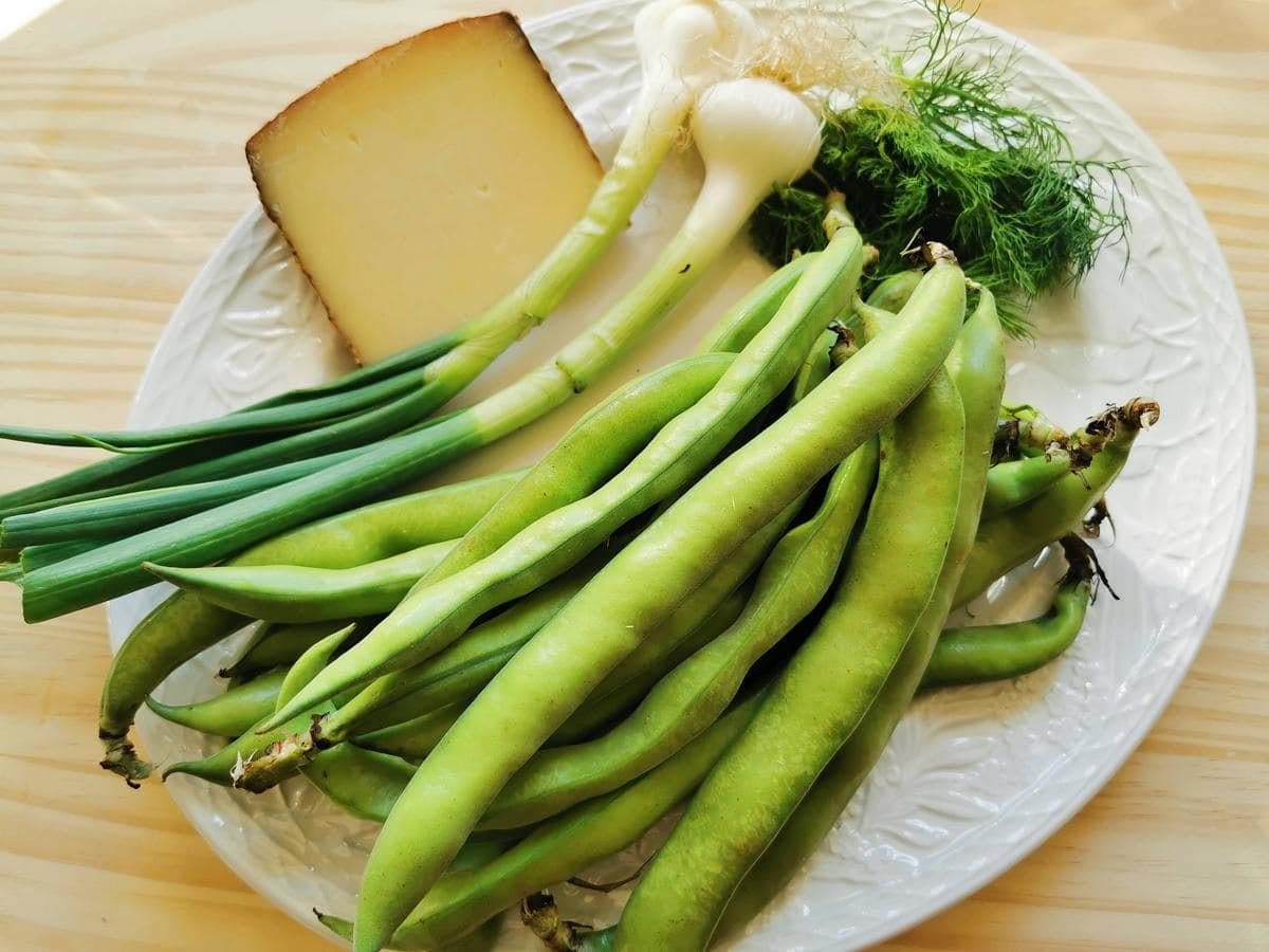 ingredients for fresh fava bean pasta on white plate