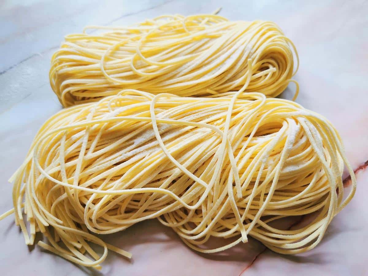 Fresh tajarin (tagliolini) from Piemonte on pink marble work top.