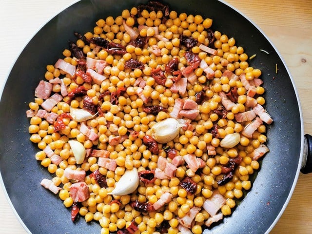 chickpeas, sweet red peppers, pancetta, rosemary and garlic cooking in skillet 