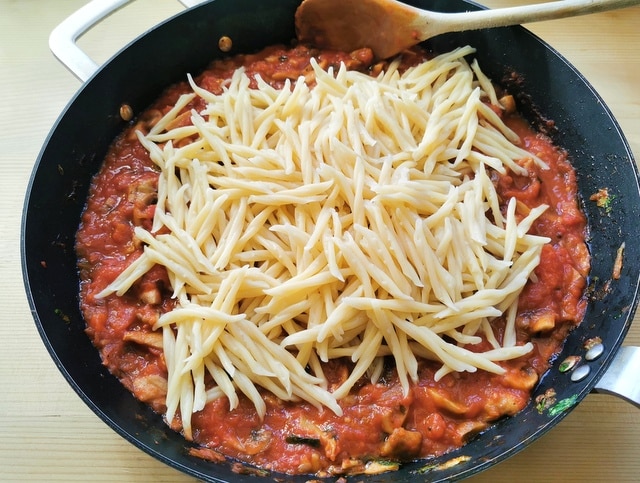 cooked trofie pasta in skillet with mushroom ragu