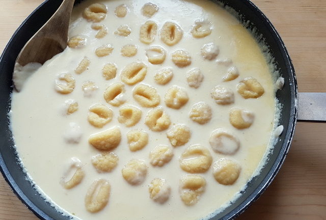 gnocchi in fontina cheese sauce in skillet