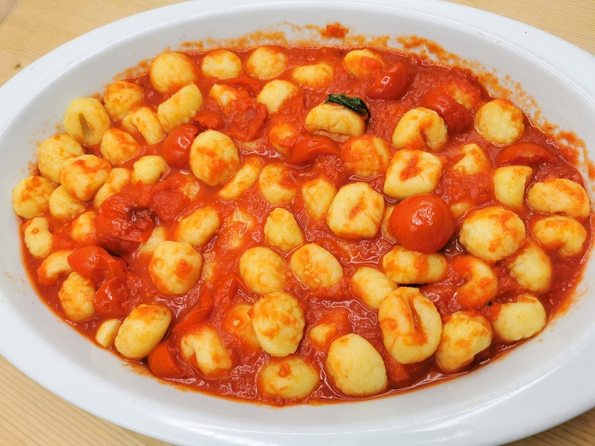 Gnocchi mixed with tomato sauce in a baking dish.