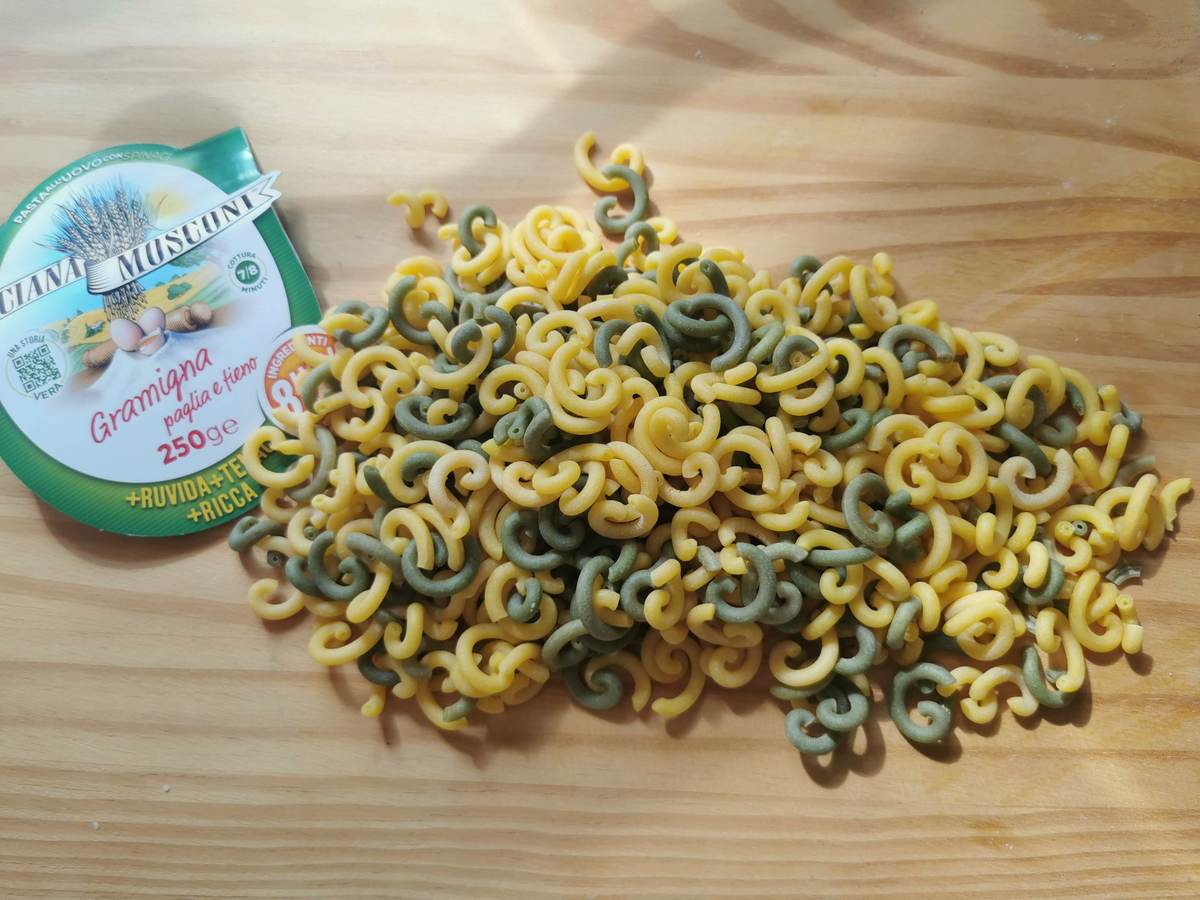 Dried gramigna pasta on wood worktop.