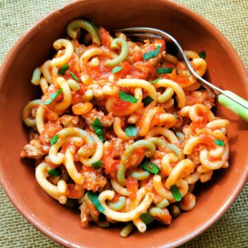 gramigna with sausage in a bowl with chopped parsley