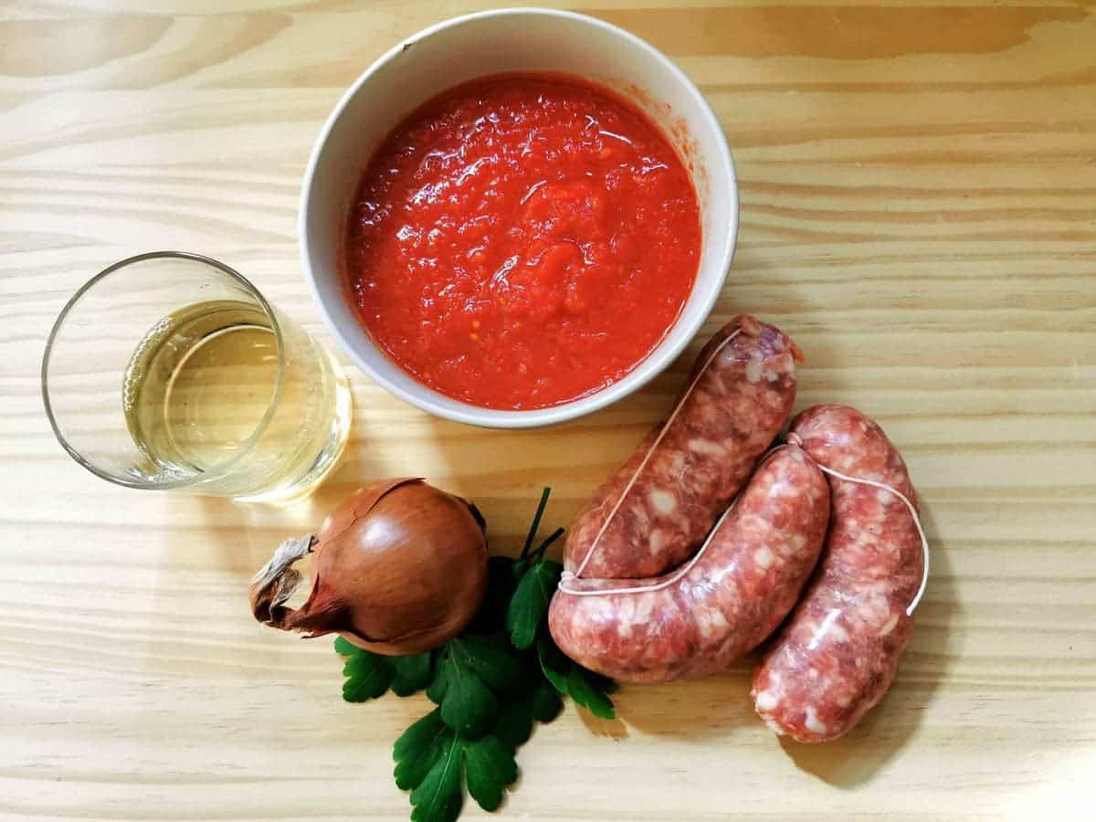 Sauasge, onion, white wine, parsley and canned tomatoes in a bowl