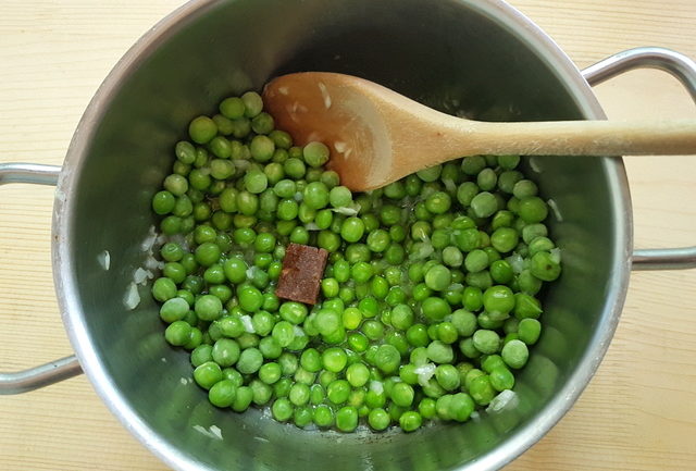 peas and chopped onions in saucepan with stock cube