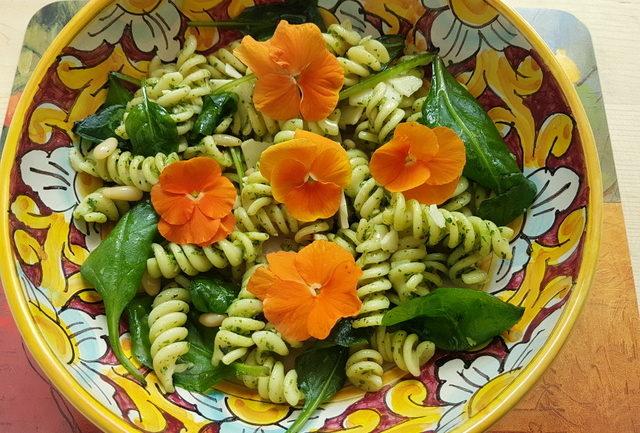 Green pasta salad with edible flowers