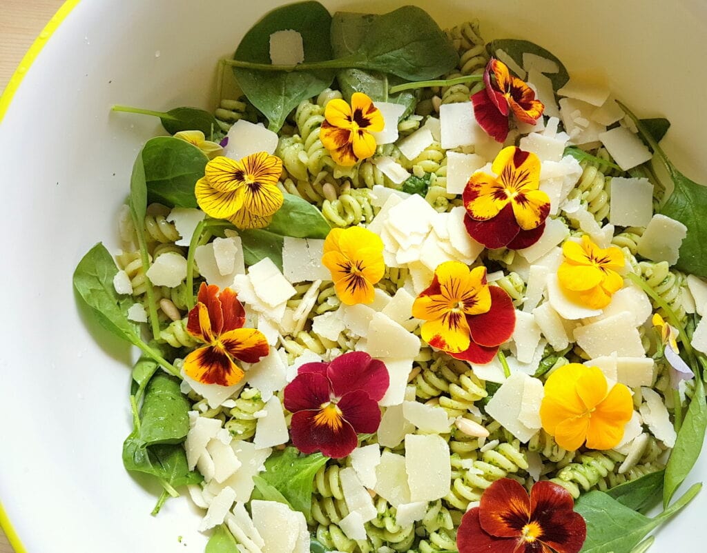 green pasta salad with edible flowers