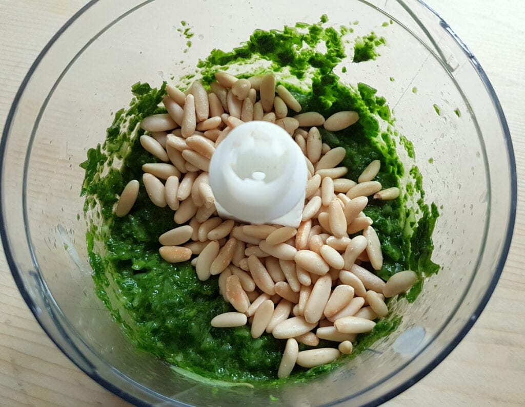 toasted pine nuts in blender with pesto