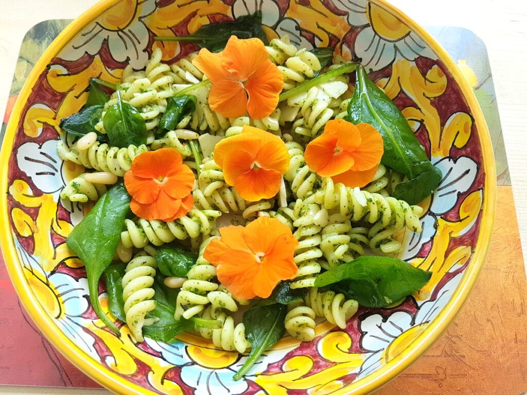 Green pasta salad with edible flowers