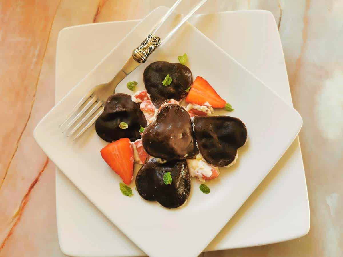 Heart-shaped chocolate ravioli with mascarpone cream and strawberries.
