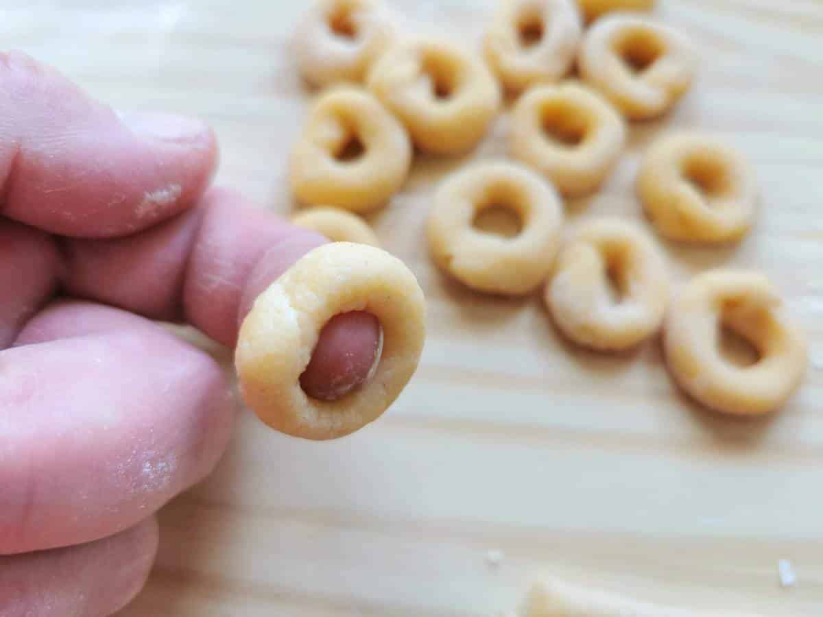 anellini pasta ring around person's index finger