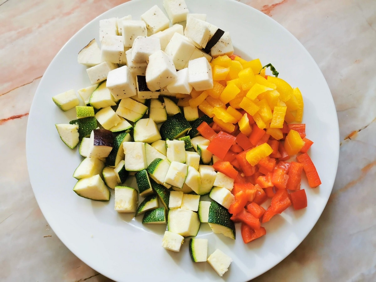 cubed eggplant, zucchini and bell peppers on white plate