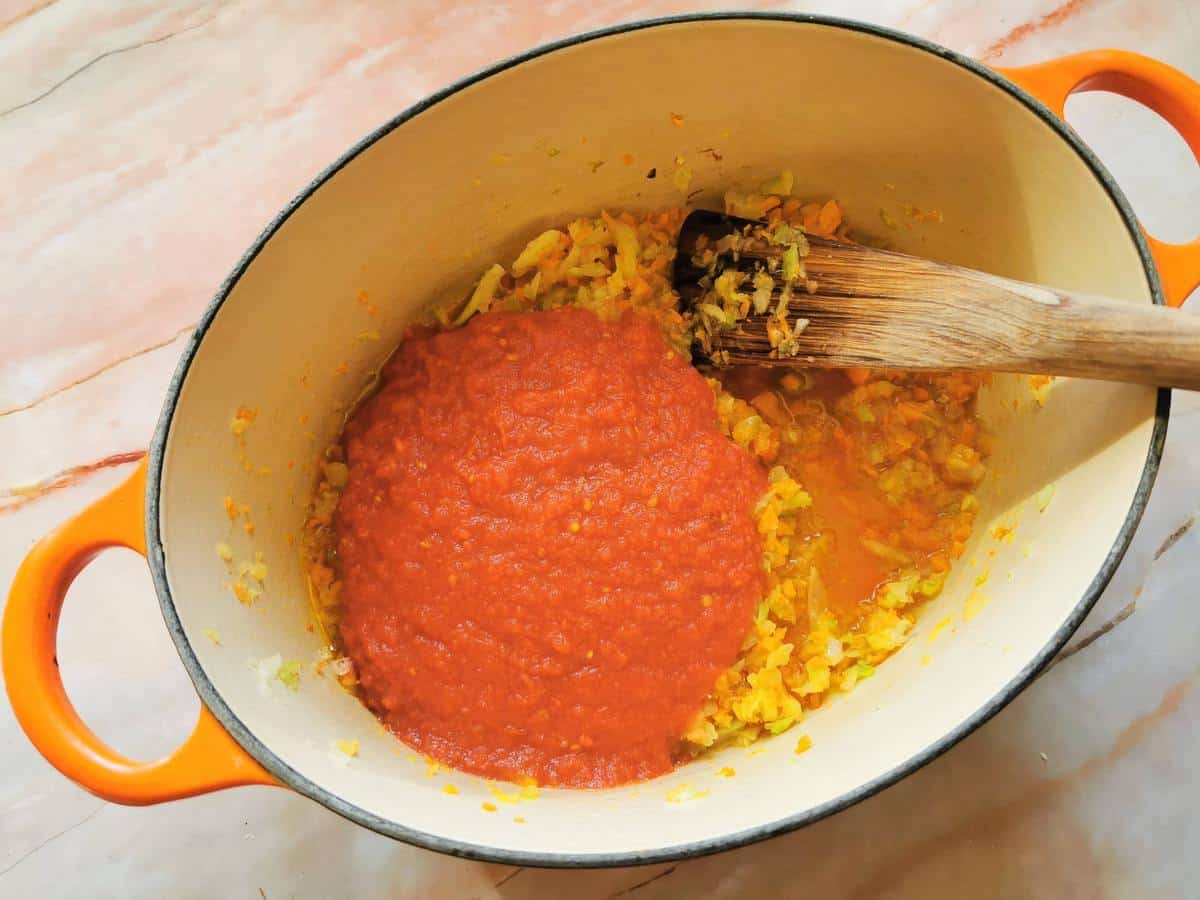 tomato passata in Dutch oven with cooked soffrito