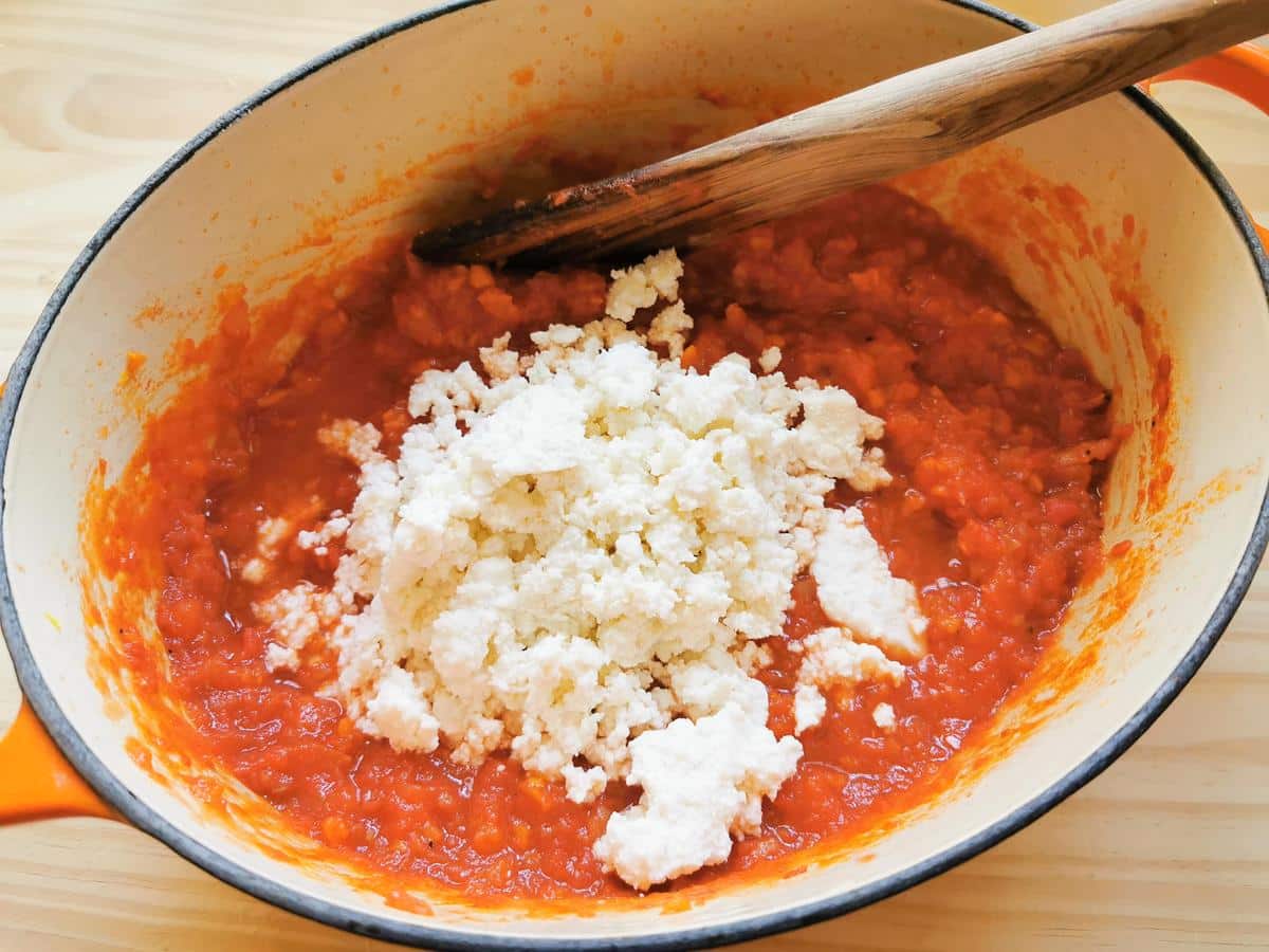 fresh ricotta added to tomato sauce in Dutch oven