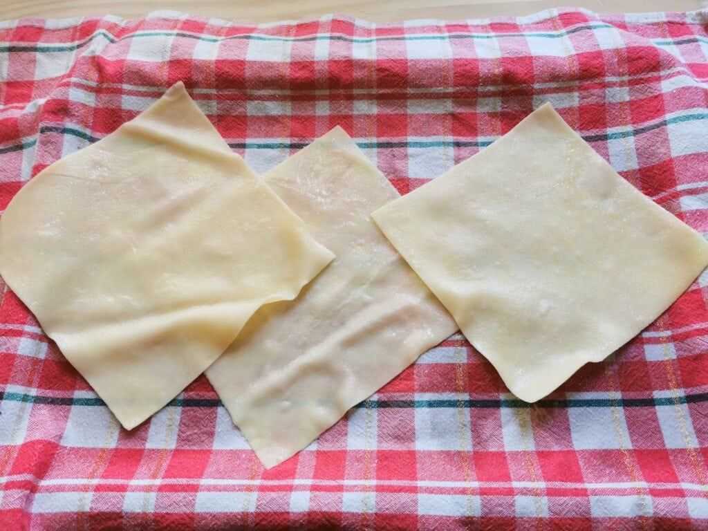 parboiled cannelloni pasta squares on red tea towel