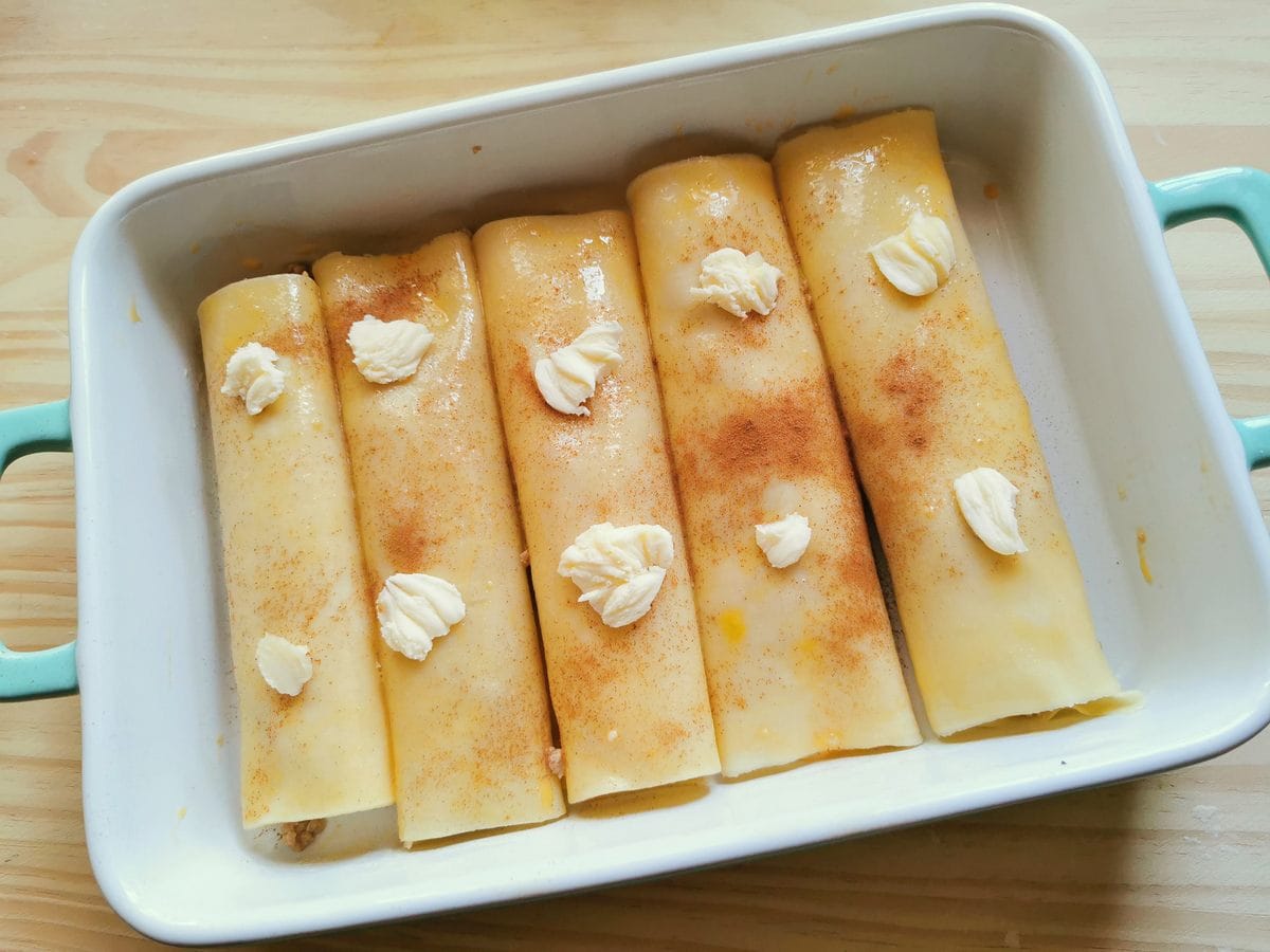 uncooked homemade cannelloni sprinkled with cinnamon in oven dish