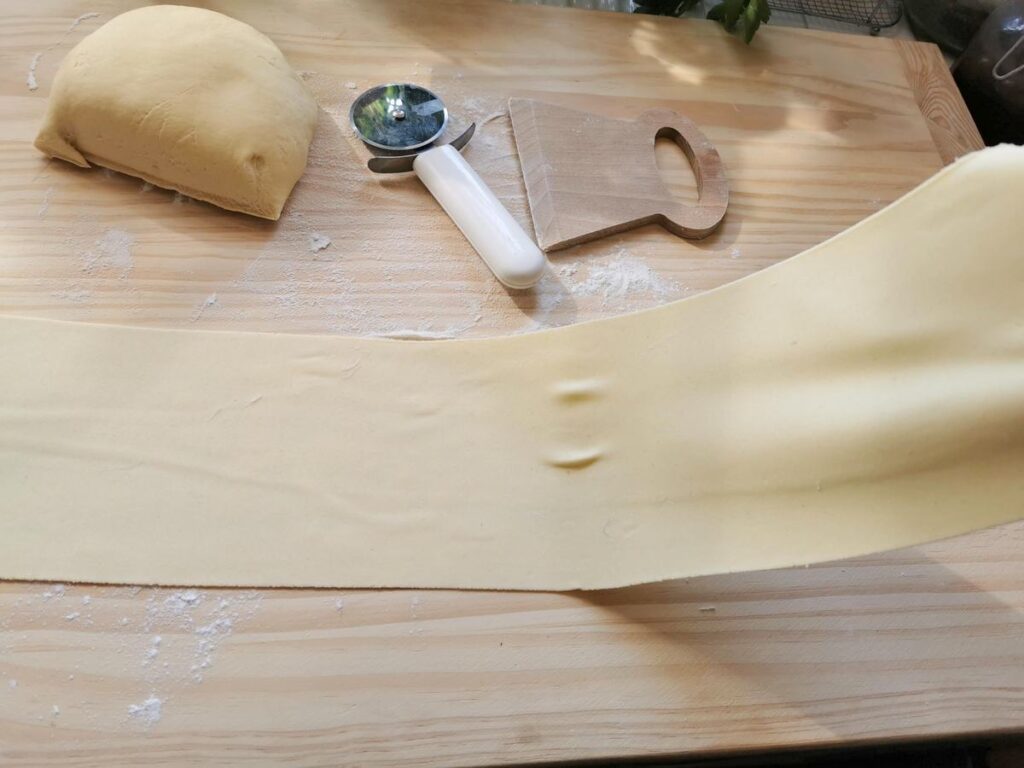 ready rolled pasta dough sheet on pastry board.