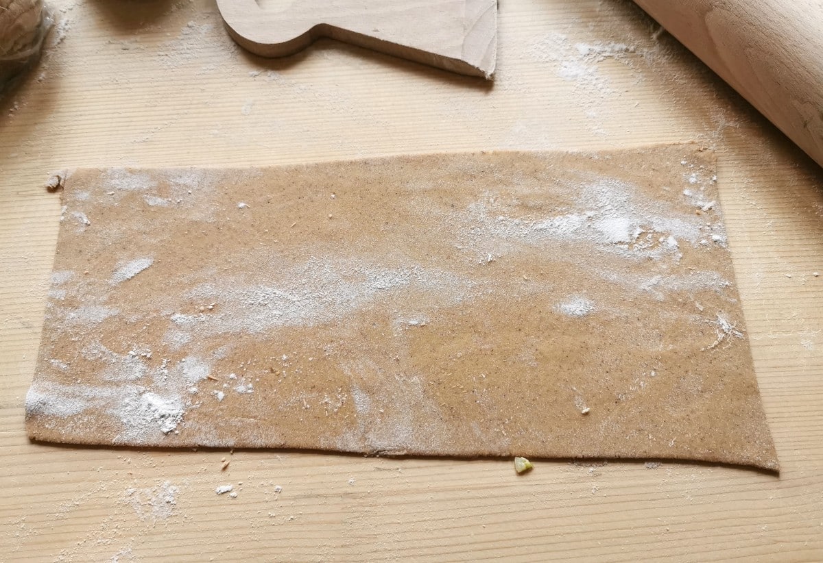 sheet of homemade chestnut pasta dough rolled out on wooden board