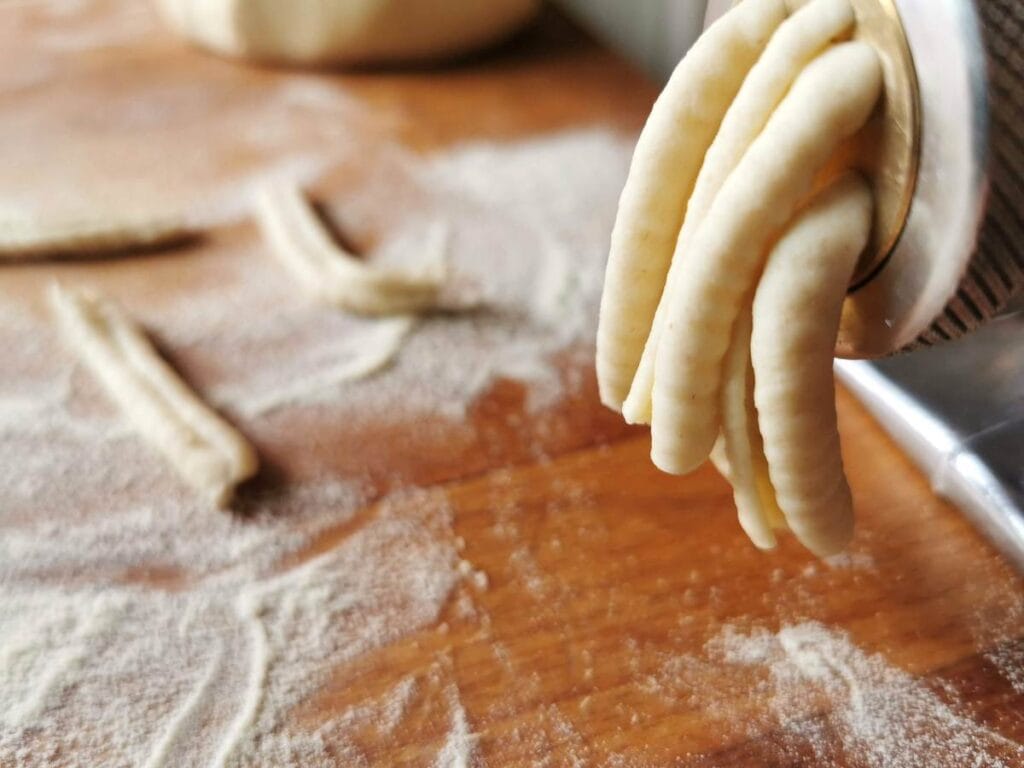 casarecce ready to be cut off from the front of the dough press.