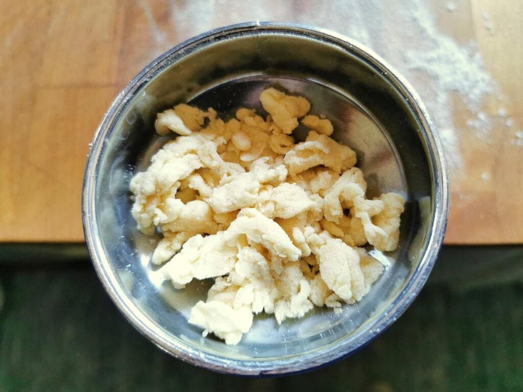 Pieces of pasta dough in the top of the dough press